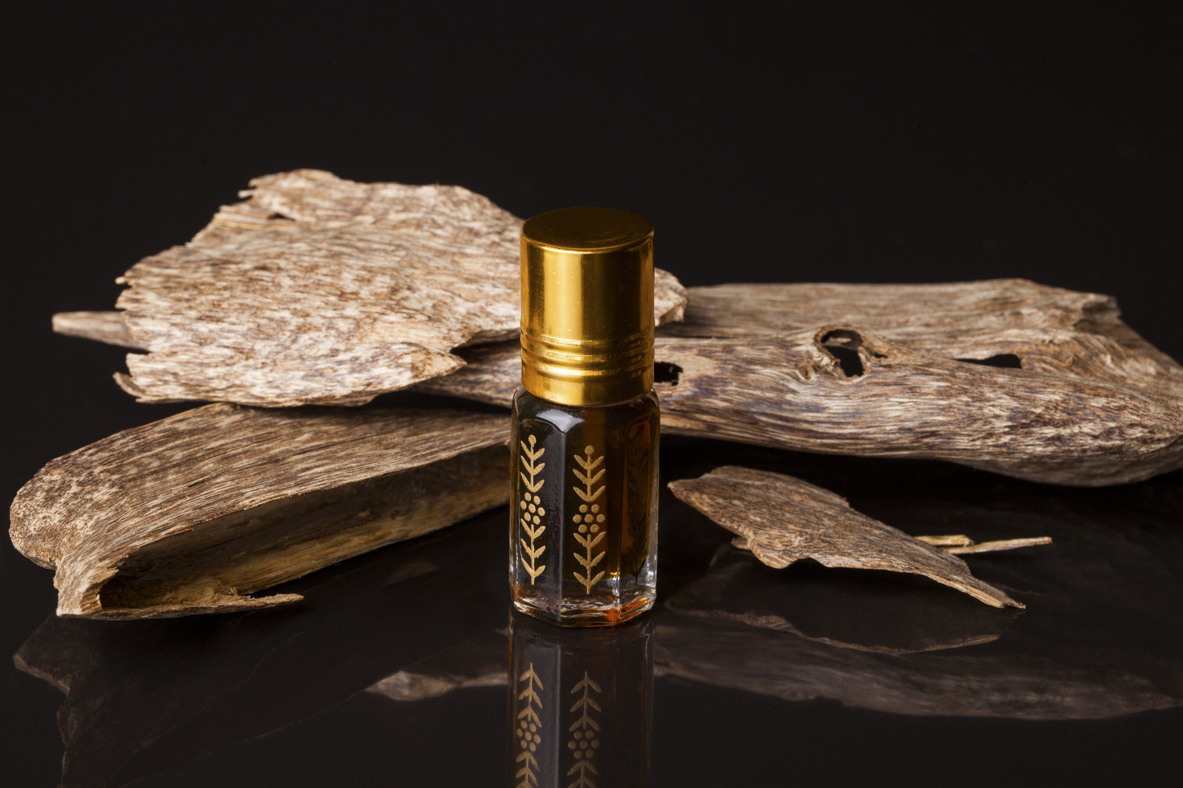 Flacon d'huile d'oud devant du bois d'agar
